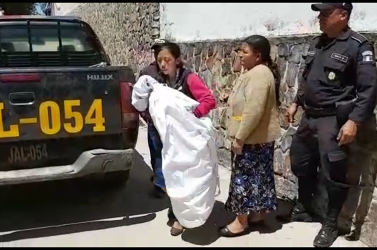 La madre del bebé, Adela Cruz, lo carga en brazos al salir de la funeraria en la cabecera de Jalapa. (Foto Prensa Libre: Hugo Oliva)