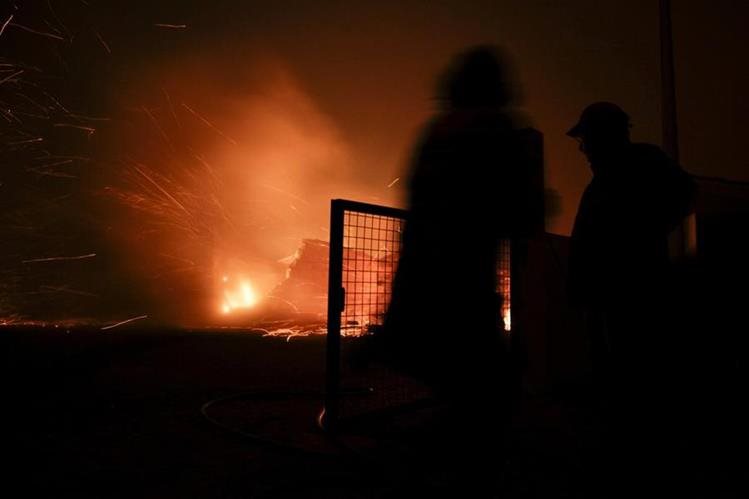 Los servicios de emergencia portugueses intentan sofocar el incendio en una de las viviendas afectadas