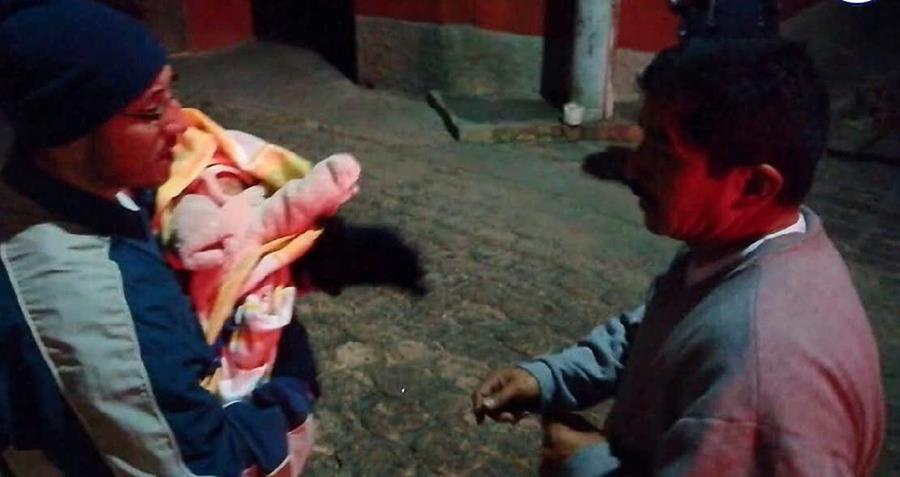 Vecino carga a bebé localizada en la ciudad de Quetzaltenango. (Foto Prensa Libre: Bomberos Voluntarios). 