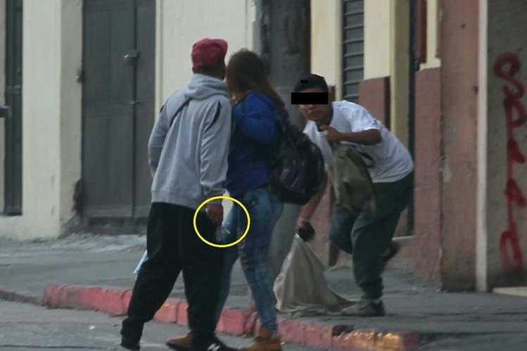 La víctima de asalto intenta alejarse de su agresor que sostiene en la mano derecha un cuchillo. (Foto Prensa Libre)
