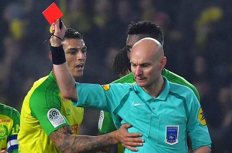 El árbitro Tony Chapron expulsó el domingo al jugador del Nantes Diego Carlos después de un accidental choqué entre ambos que provocó la caída del silbante. (Foto Prensa Libre: AFP)
