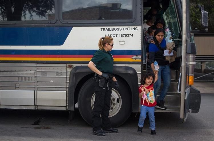 Grupo de inmigrantes son dejados en una estación de autobuses poco después de ser liberados en McAllen, Texas. (AFP).