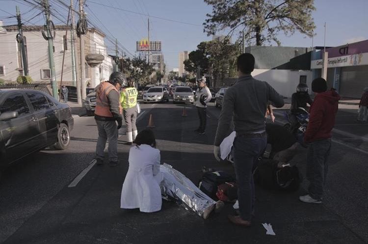 Voluntarios auxilian a las víctimas, atropelladas por un vehículo que huyó. (Foto Prensa Libre: Fabriccio Díaz).