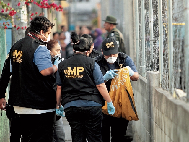 Personal del Ministerio Público revisa una bolsa donde se encontraron partes del cuerpo  de una mujer, en la colonia Alameda 2, zona 18. (Foto Prensa Libre: Érick Ávila)