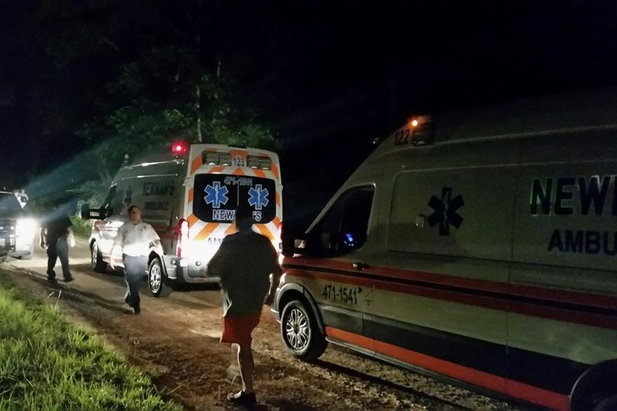 Ambulancias esperan en el exterior de la vivienda donde se produjo e hallazgo de los cuerpos sin vida. (Foto Prensa Libre: AP).