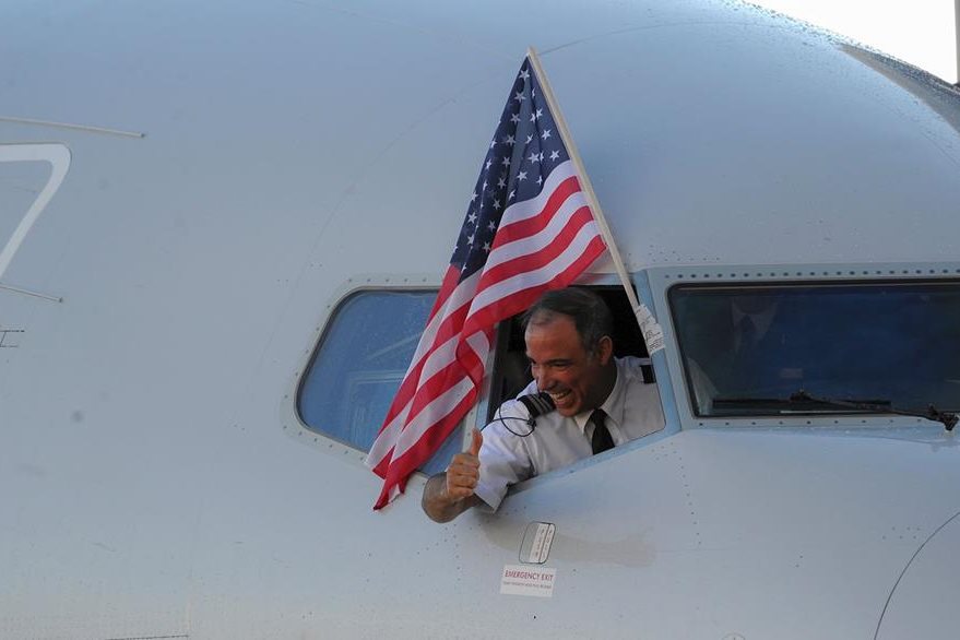 Un integrante de la tripulación saluda al arriba a Cuba. (Foto Prensa Libre: AFP).