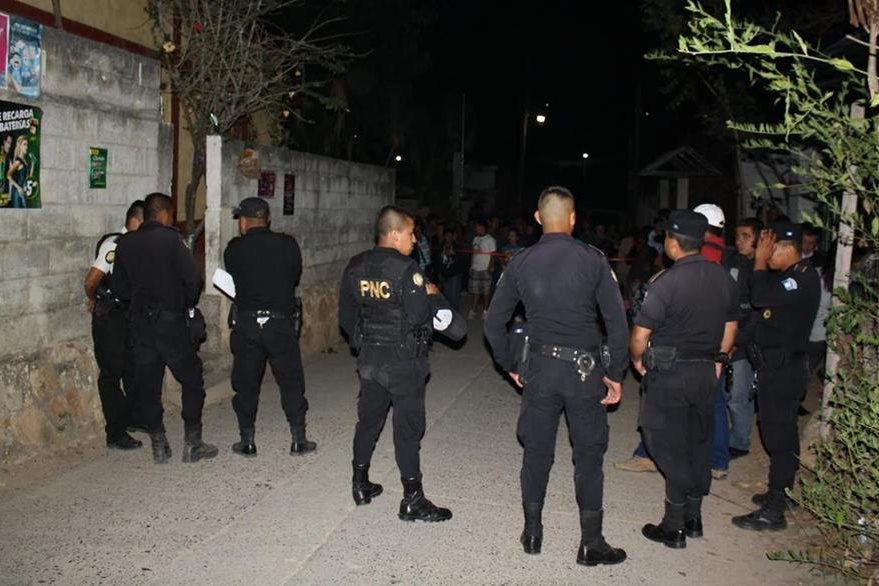 Vecinos de San Antonio La Paz observan labor de autoridades en la casa de una fémina hallada muerta. (Foto Prensa Libre: Héctor Contreras)