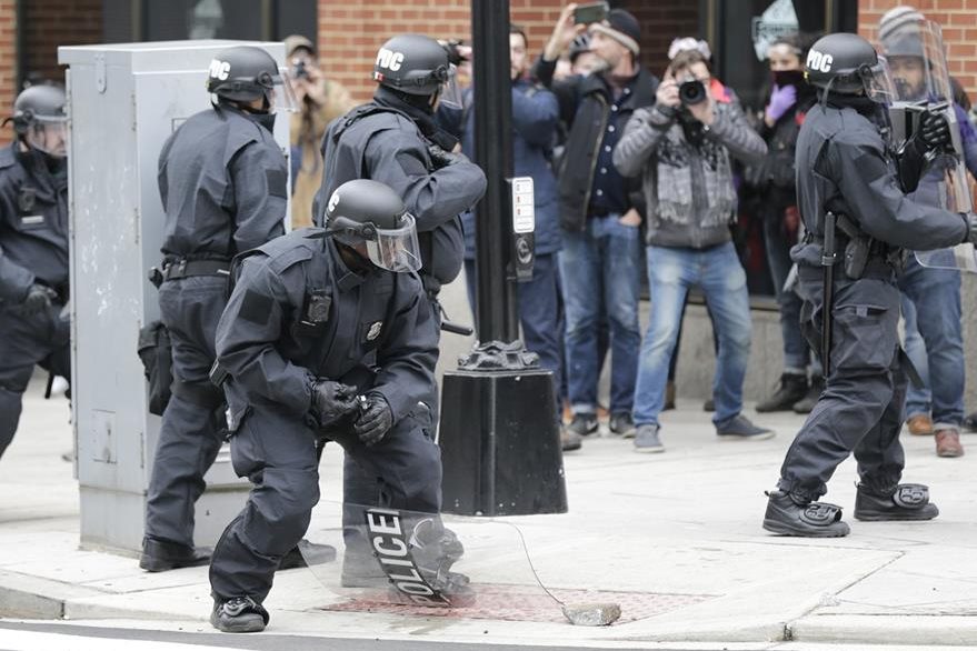 Un policía trata de resguardarse durante las manifestaciones en Washington. (Foto Prensa Libre: AP)