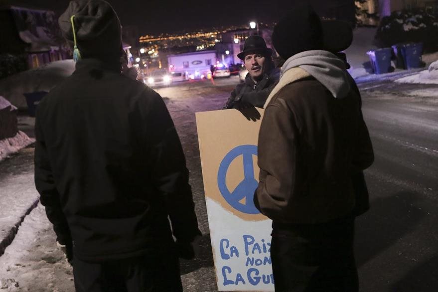 Un activista manifesta contra violencia cerca de la mezquita de Quebec.(AFP).