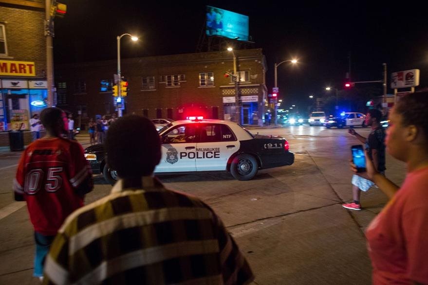Descontentos acosan a una patrulla, en Milwaukee. (Foto Prensa Libre: AFP)