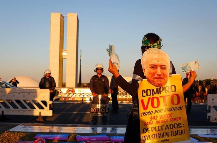 Activistas protestan contra el presidente Temer frente a la Congreso en Brasilia. (AP).